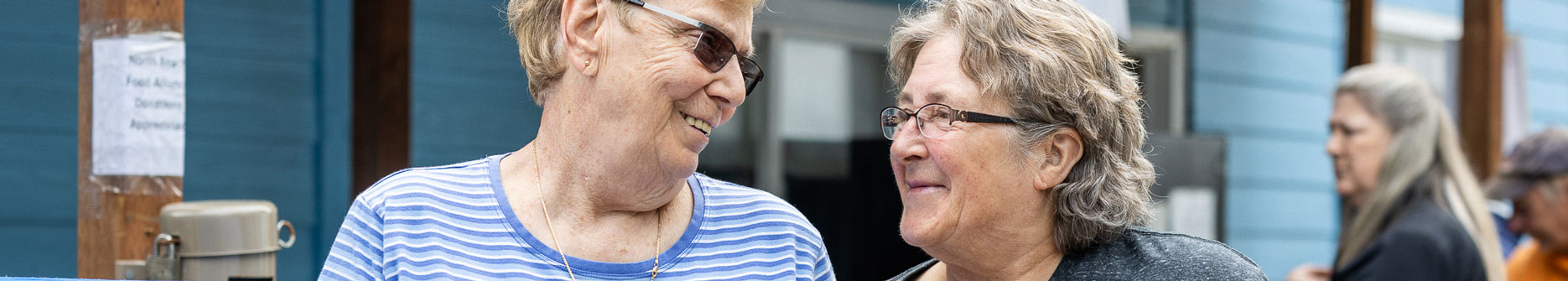 two women smiling at each other at a food bank